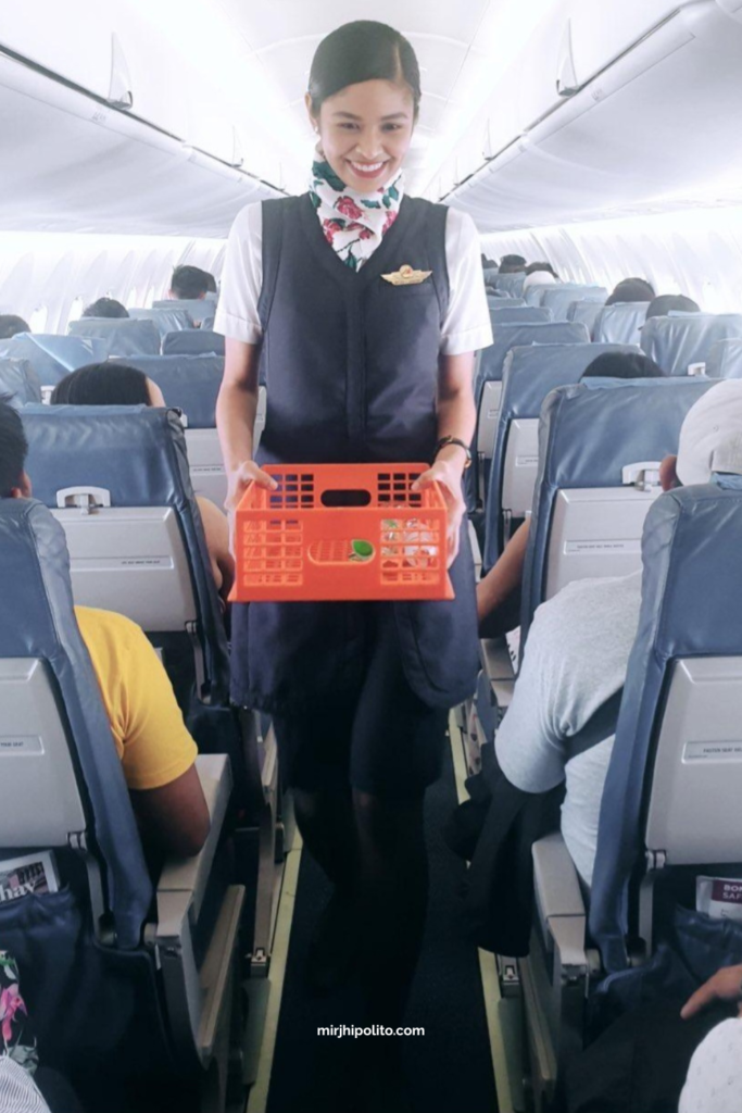 Flight attendant serves snacks inside a plane